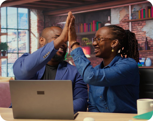 A man and woman high-fiving each other in an office
